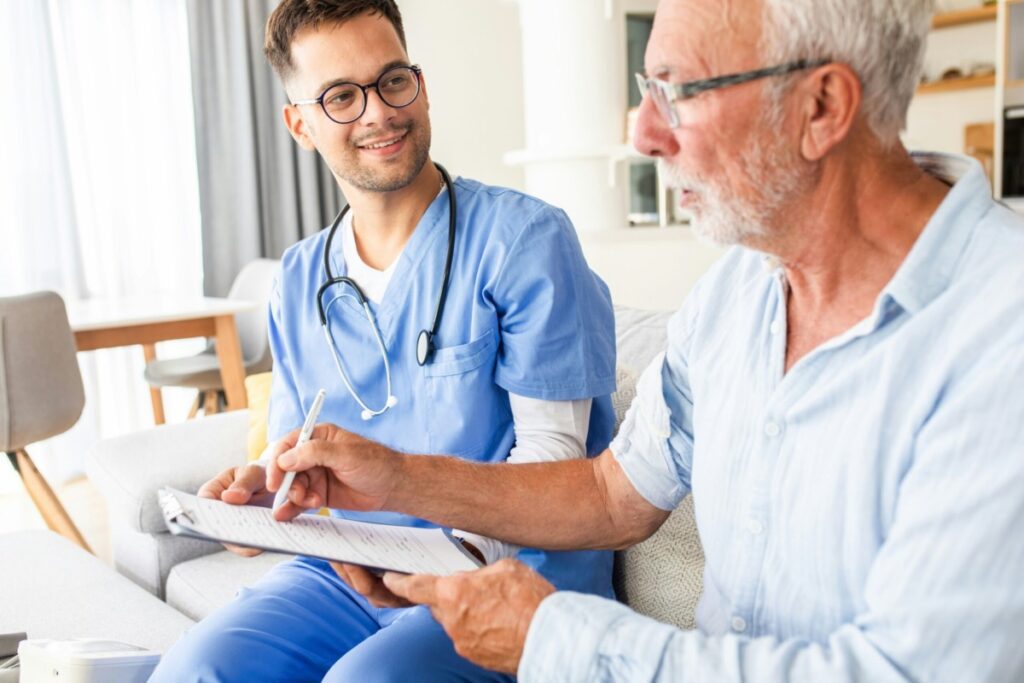 Male nurse speaking with older man.